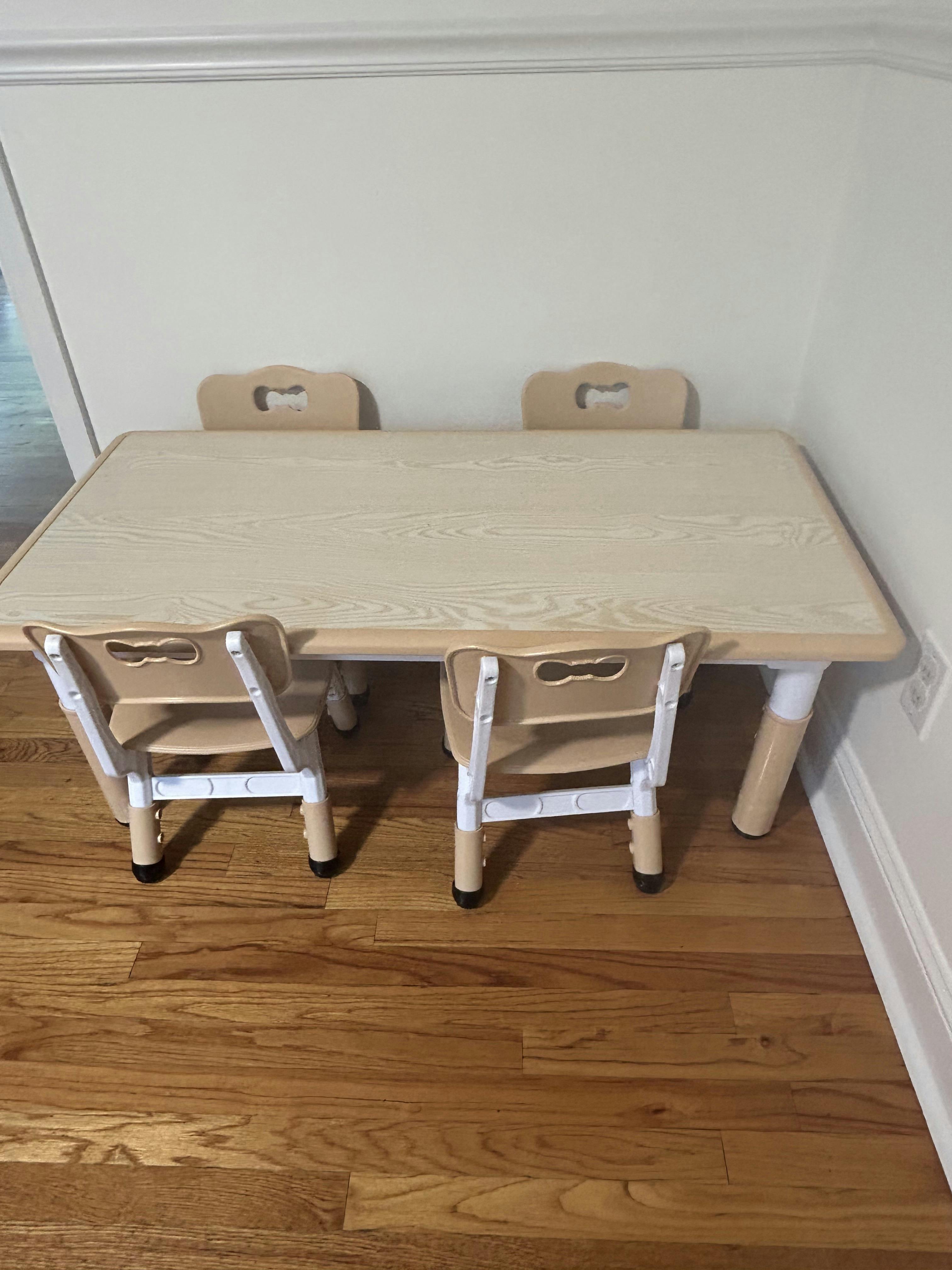 A light wood-grain children's table with three chairs tucked underneath