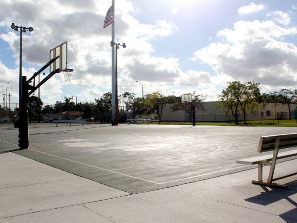 Outdoor basketball court with a hoop and a bench