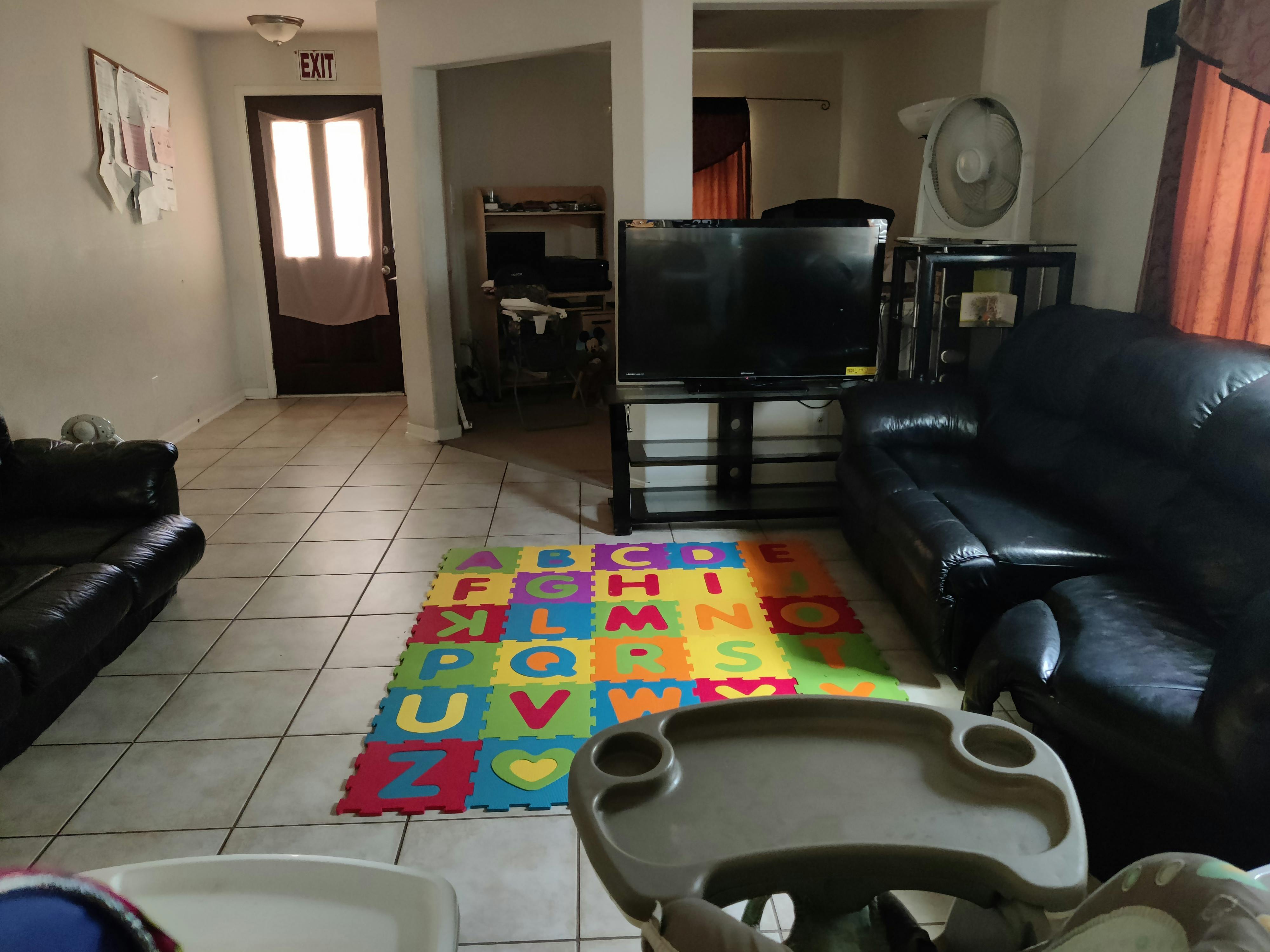 Living room with a colorful alphabet playmat on the floor