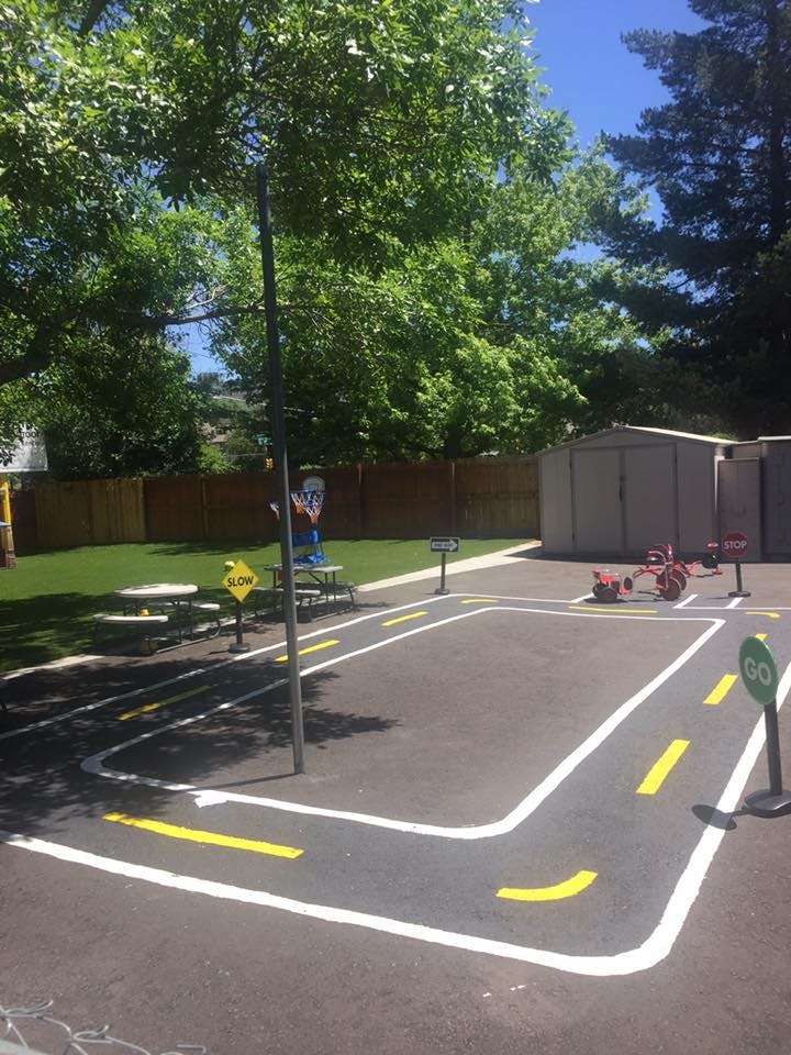 Miniature road with painted lines and a "GO" sign in a play area
