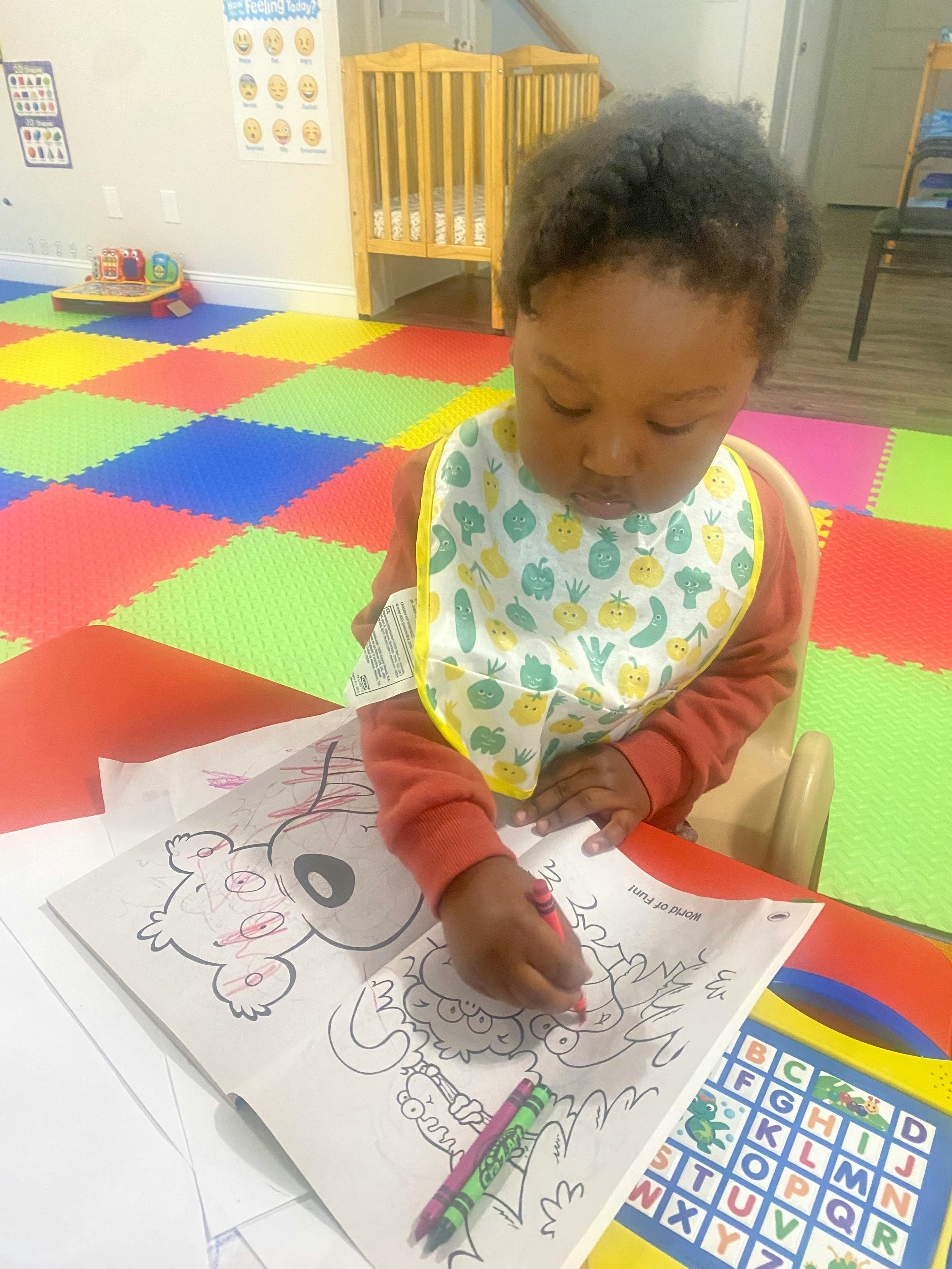 Child coloring in a coloring book with a crayon