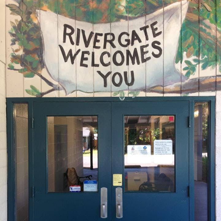 Rivergate Welcomes You sign above a blue double door entrance