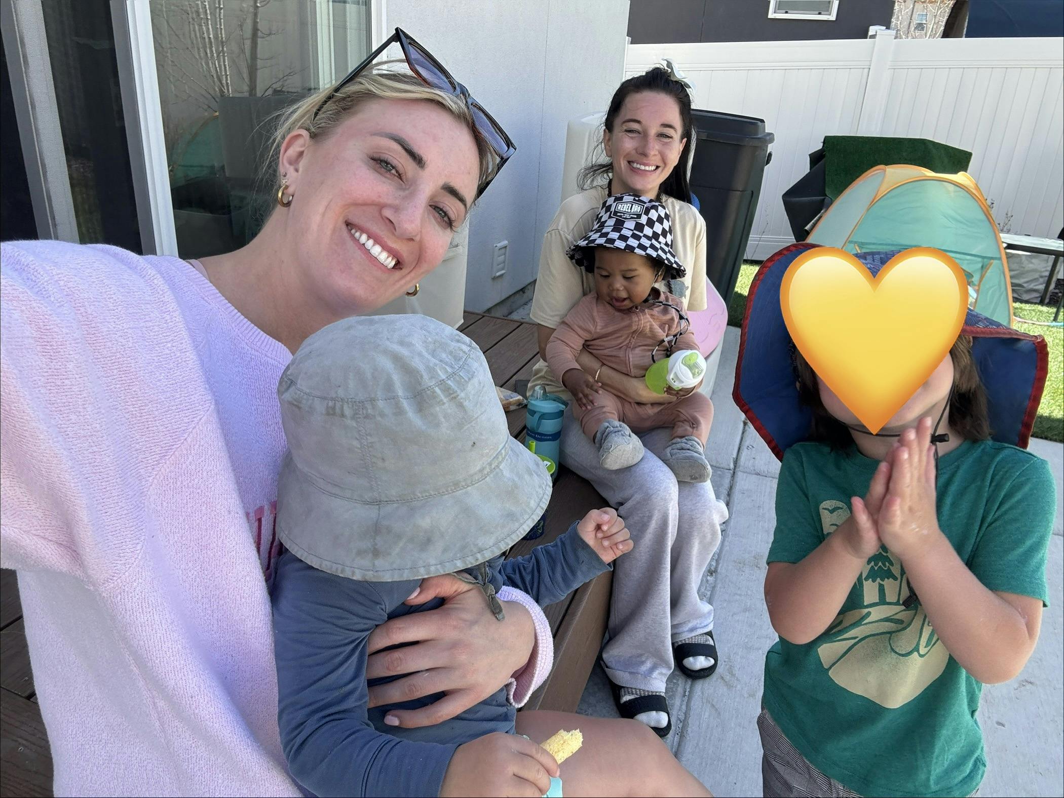 Two people with three children on a patio
