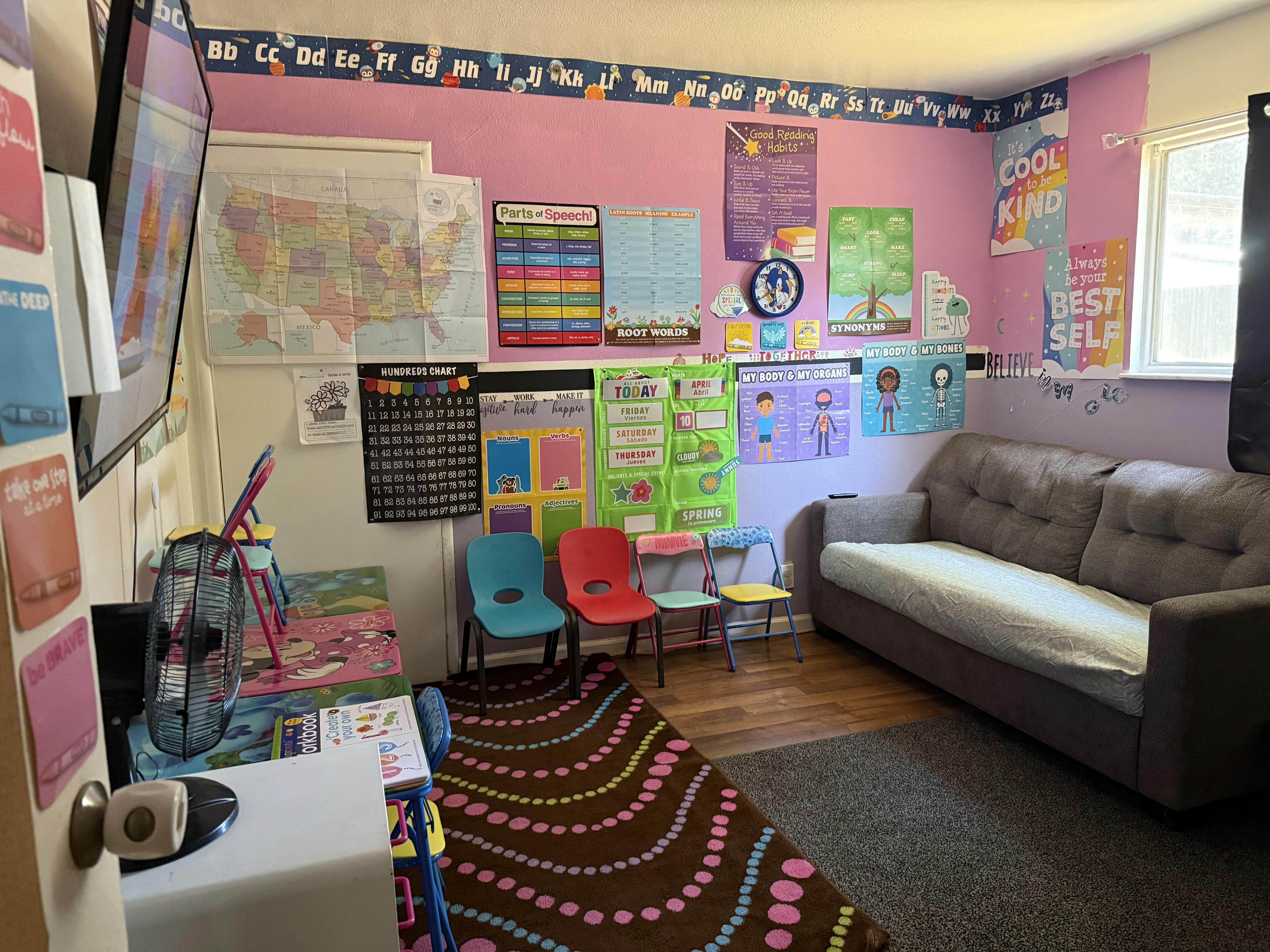 Classroom interior with educational posters, small chairs, and a sofa