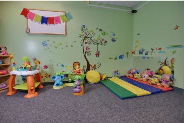 Playroom with colorful toys, wall decals, and a soft mat