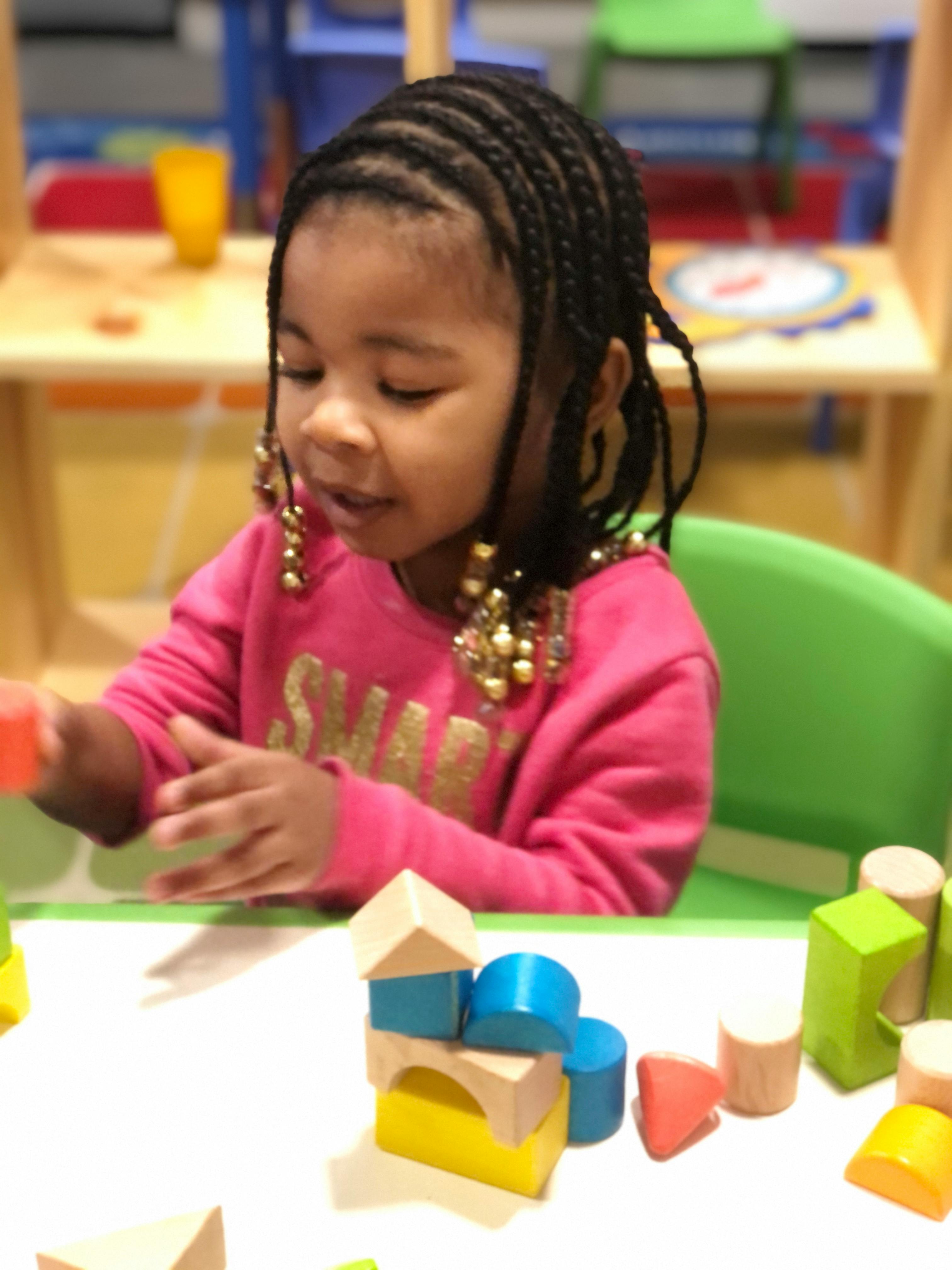 Child playing with building blocks at a table