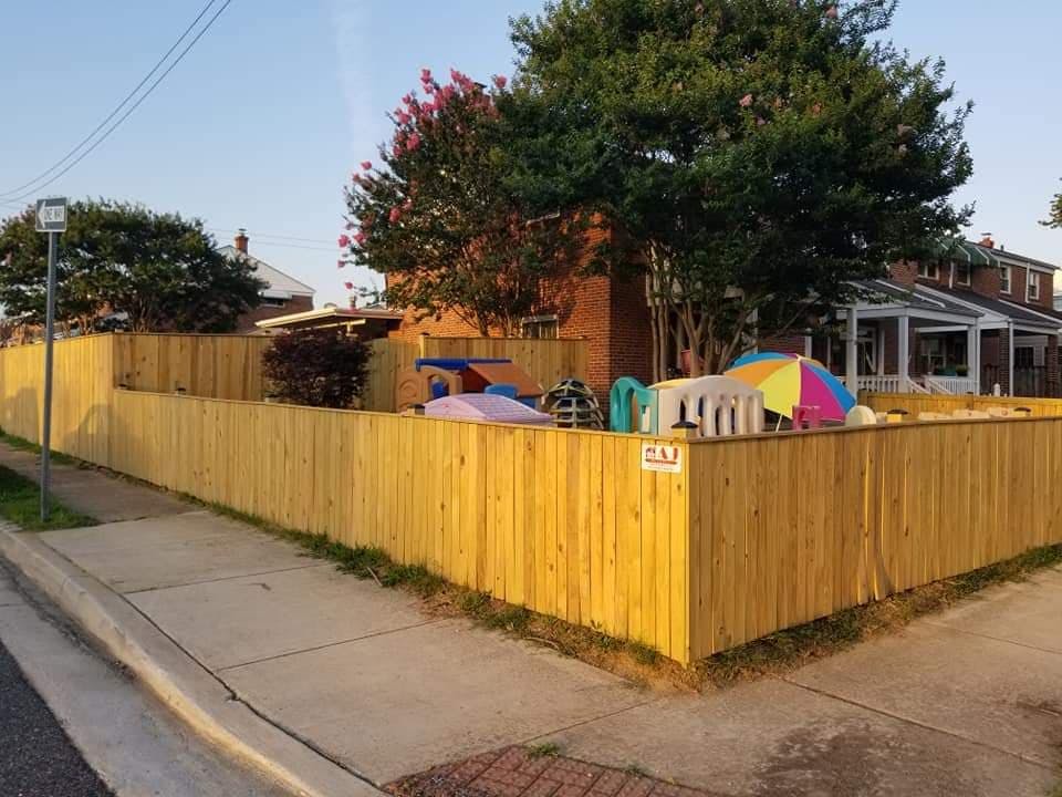 Wooden fence enclosing a yard with play equipment