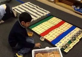 Child on floor working with math materials