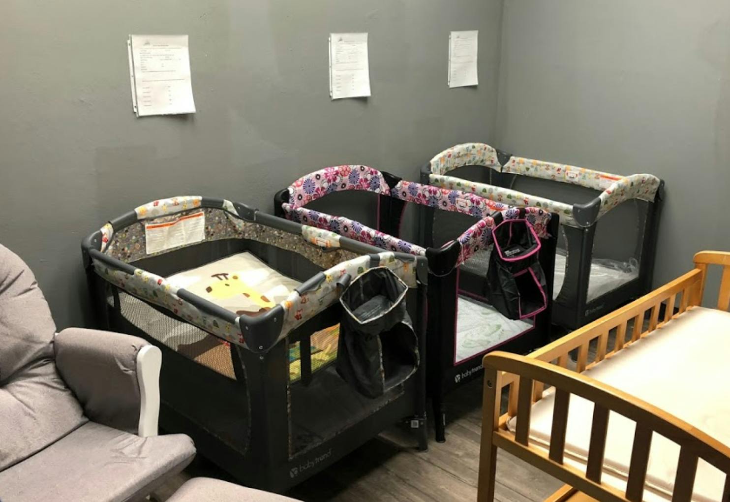 Multiple cribs and playards in a room