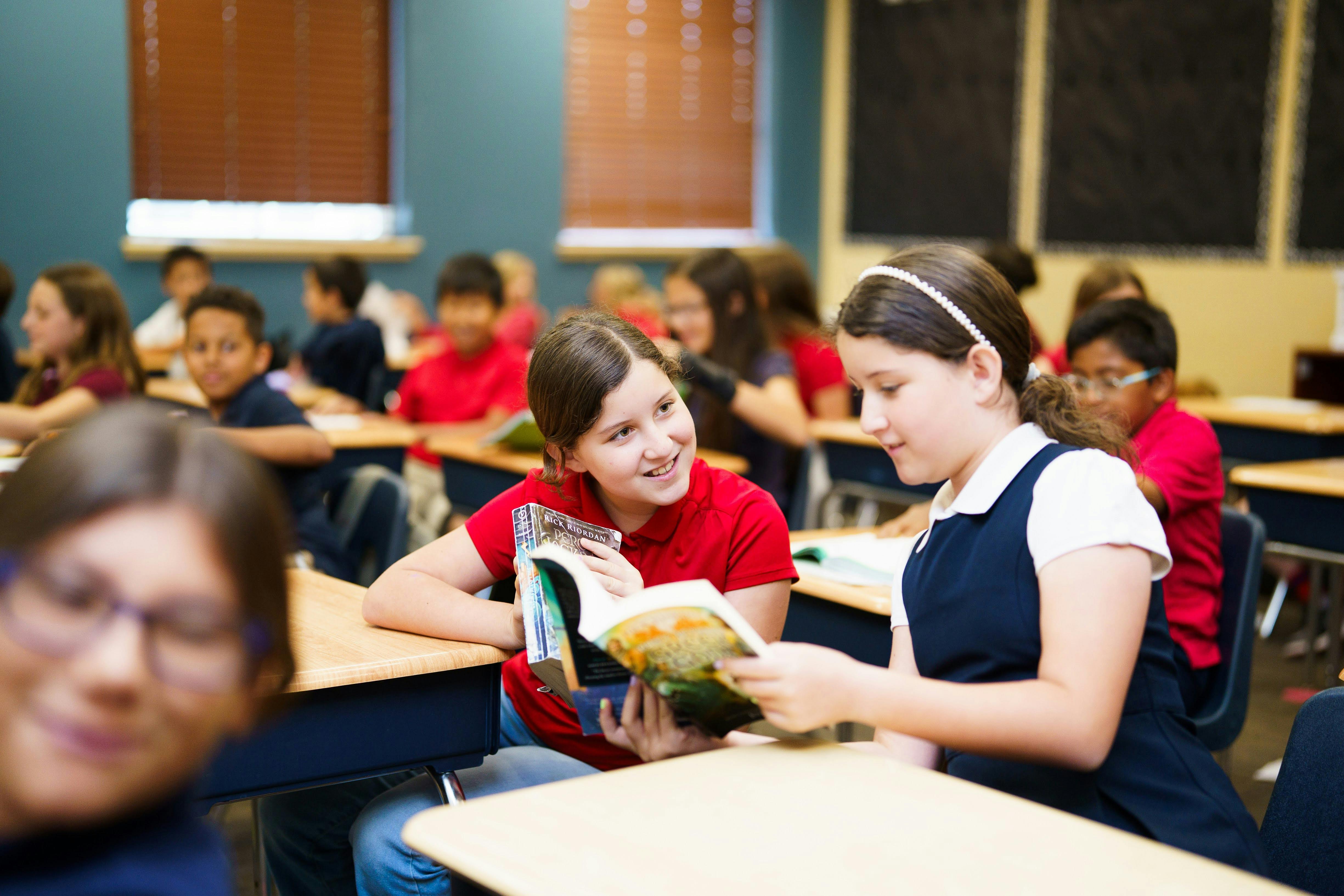Two children sharing a book in a classroom