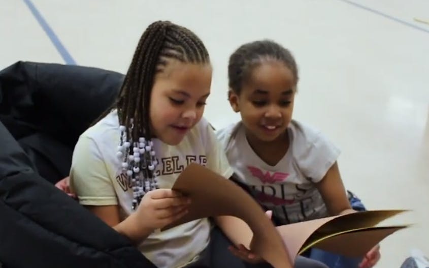 Two children looking at a book together