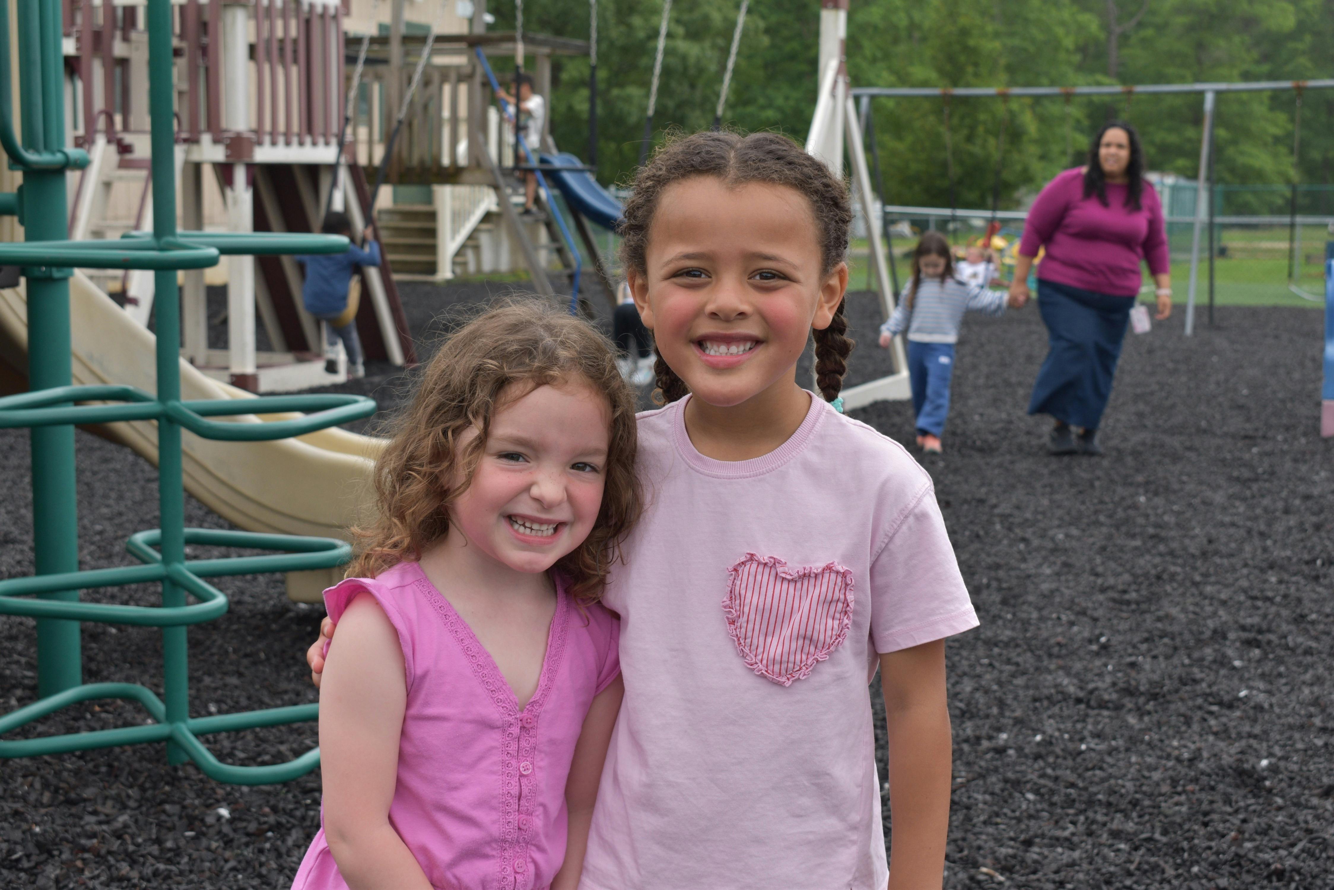 Two children smiling at a playground