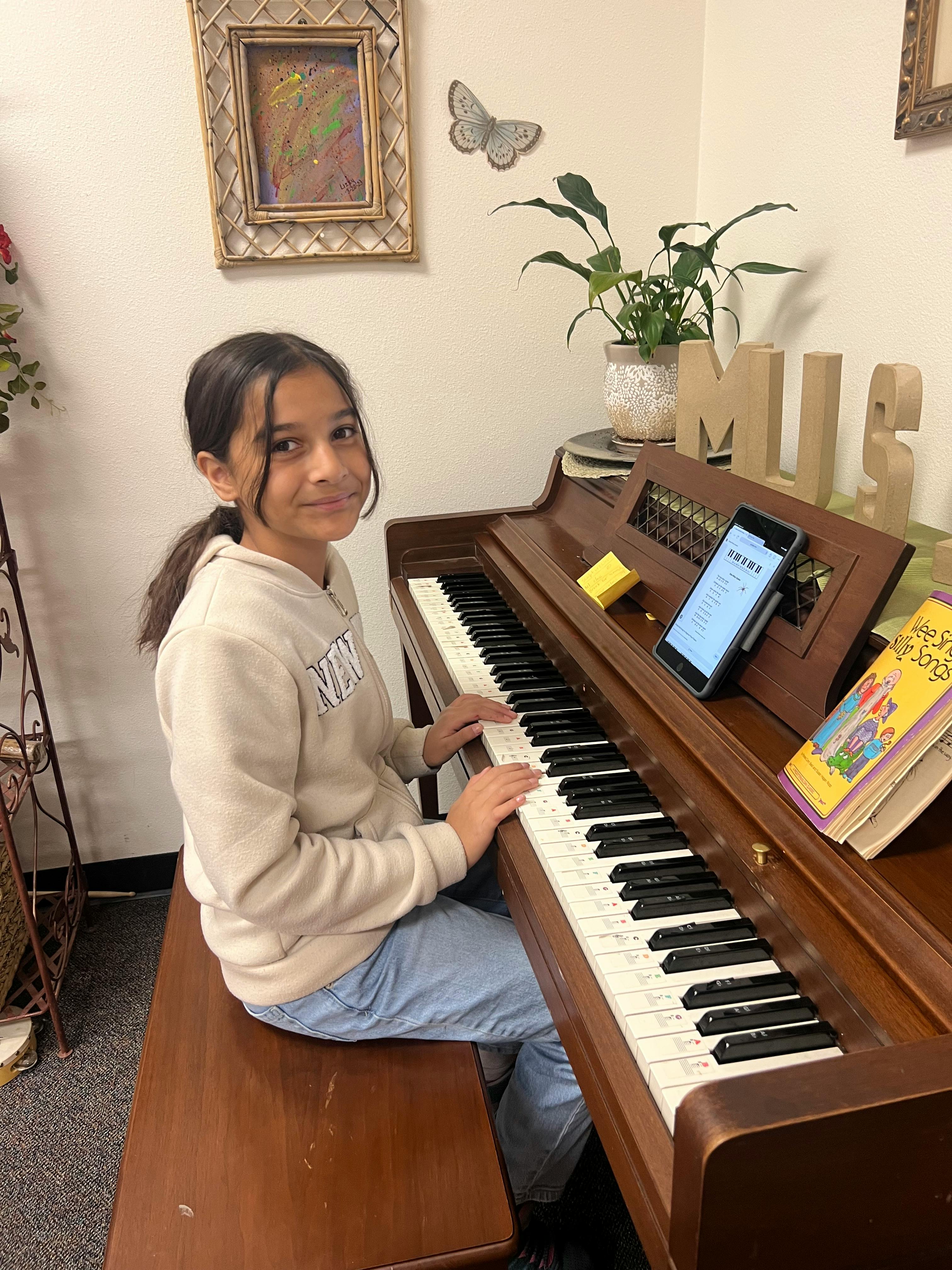 Child sitting at a piano with hands on the keys