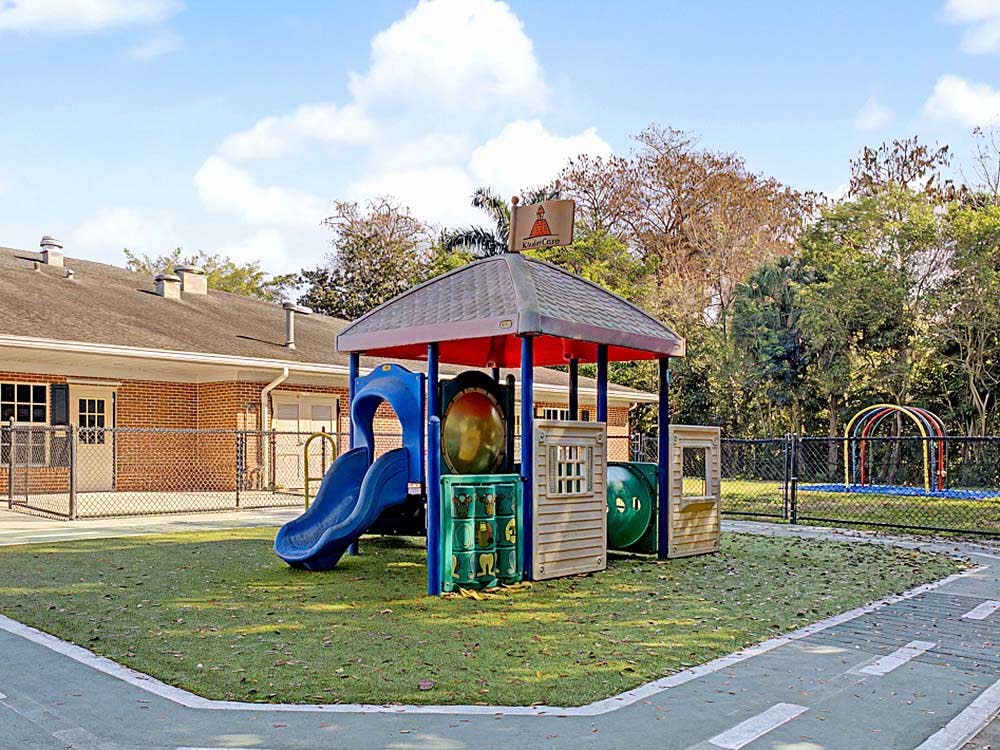 Playground structure with slide, tunnel, and climbing area on artificial turf