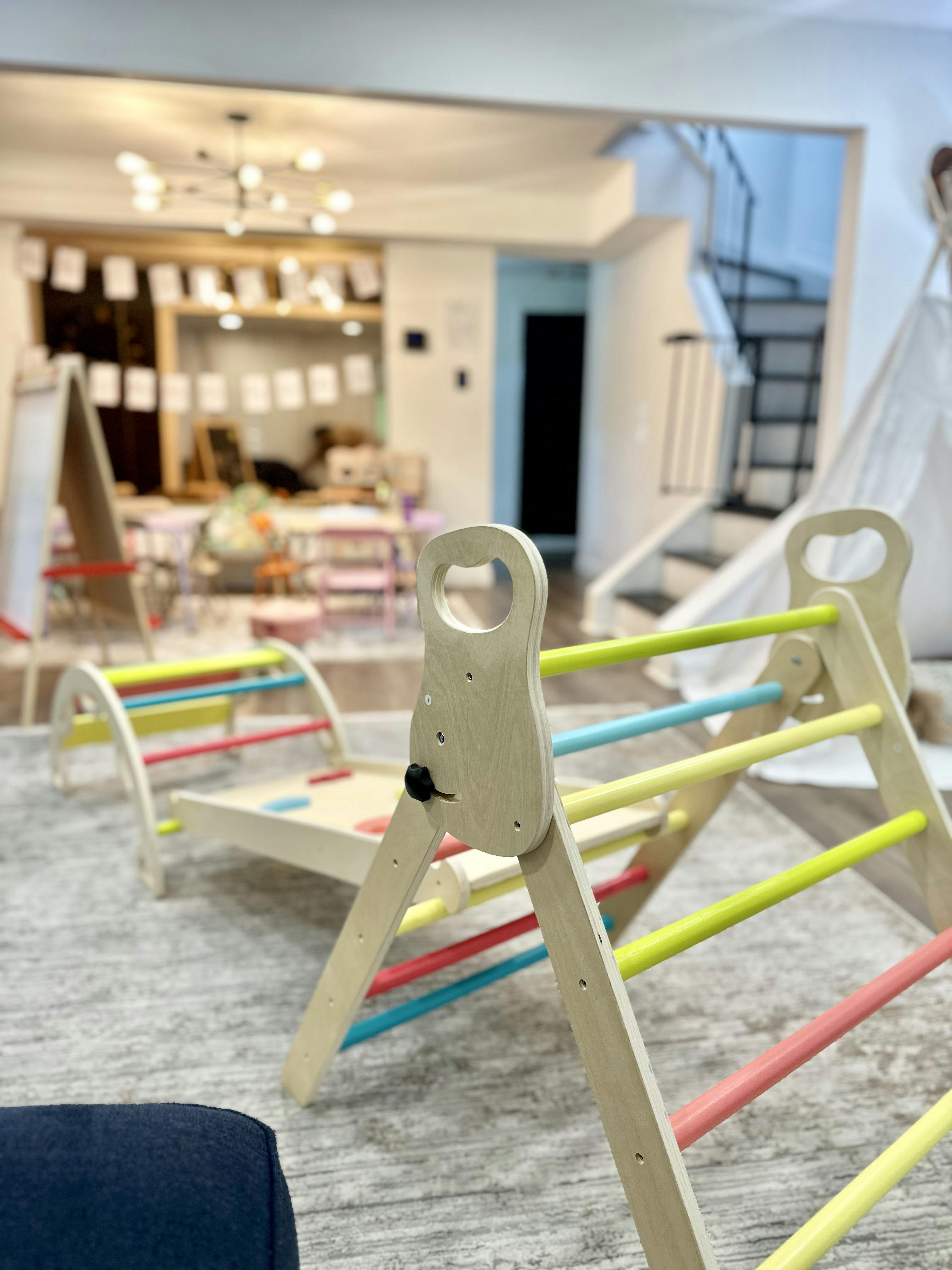 Wooden indoor climbing structure with colorful rungs