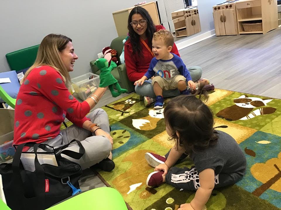 Adult using a puppet with children in a classroom