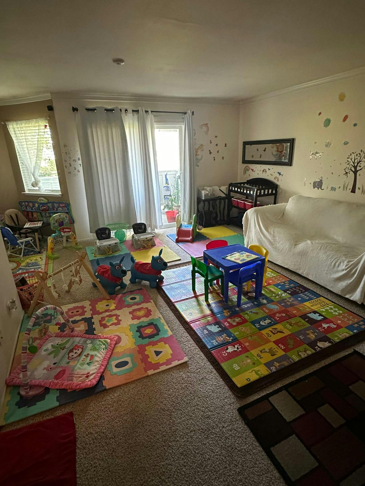 Playroom with colorful mats, small tables, and toys