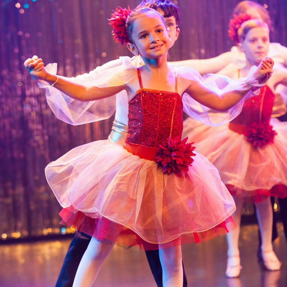 Child in a red and white tutu dancing on stage