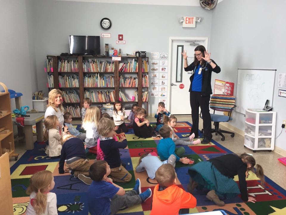 Adults interacting with children in a classroom