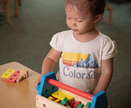Child playing with a colorful wooden toy
