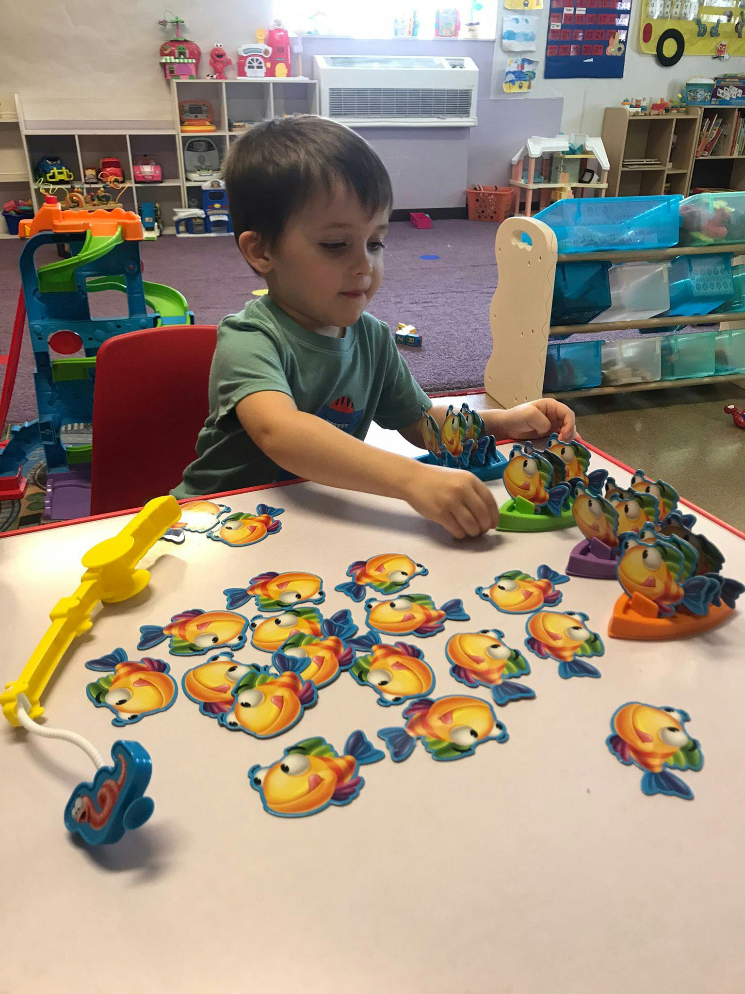 Child playing with a fishing game at a table