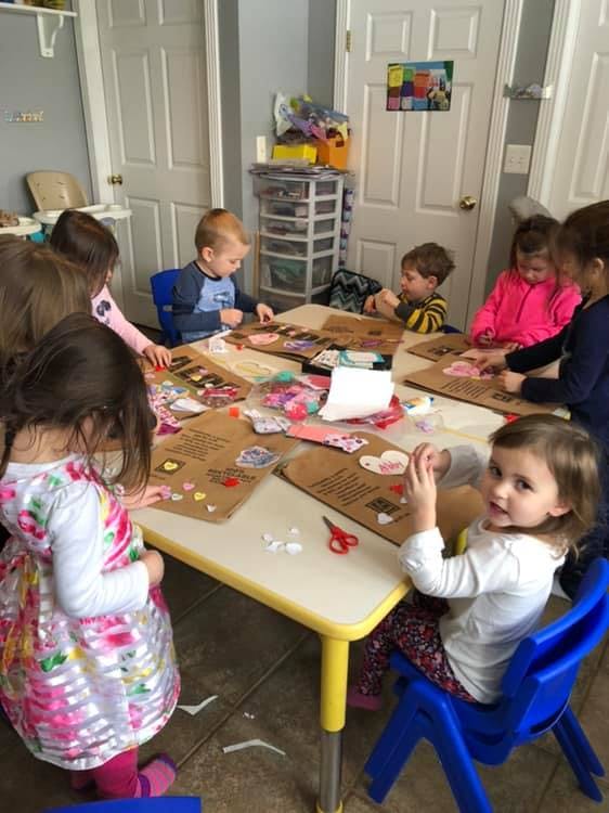 Children sitting at a table doing crafts
