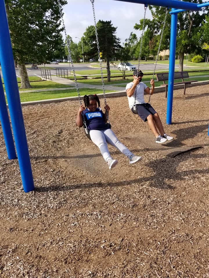 Child and person swinging on a playground