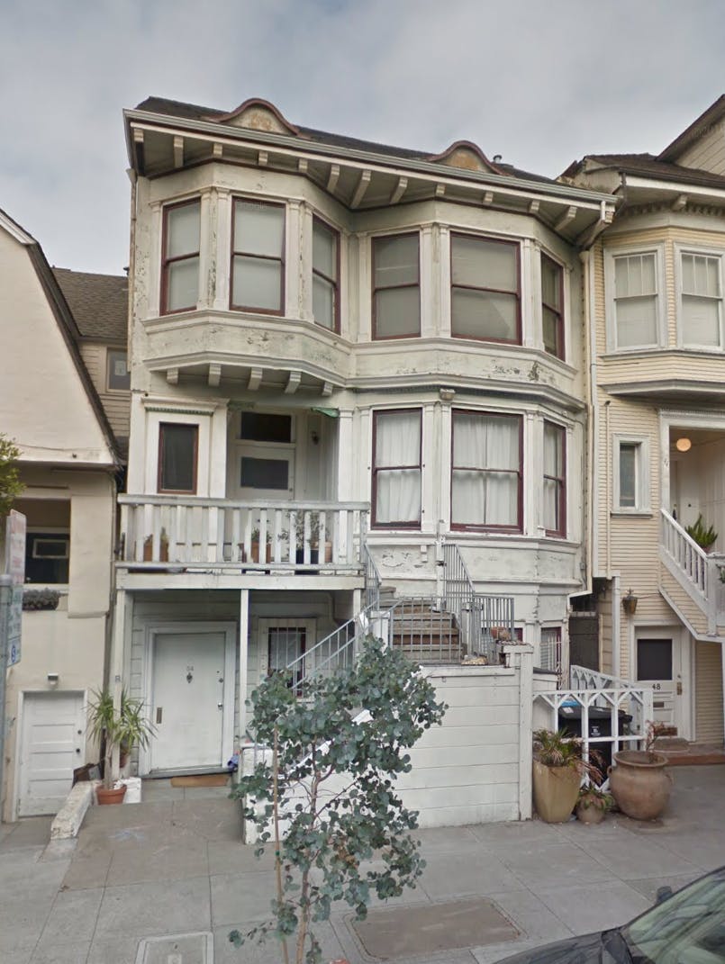 Victorian-style house with bay windows and a balcony