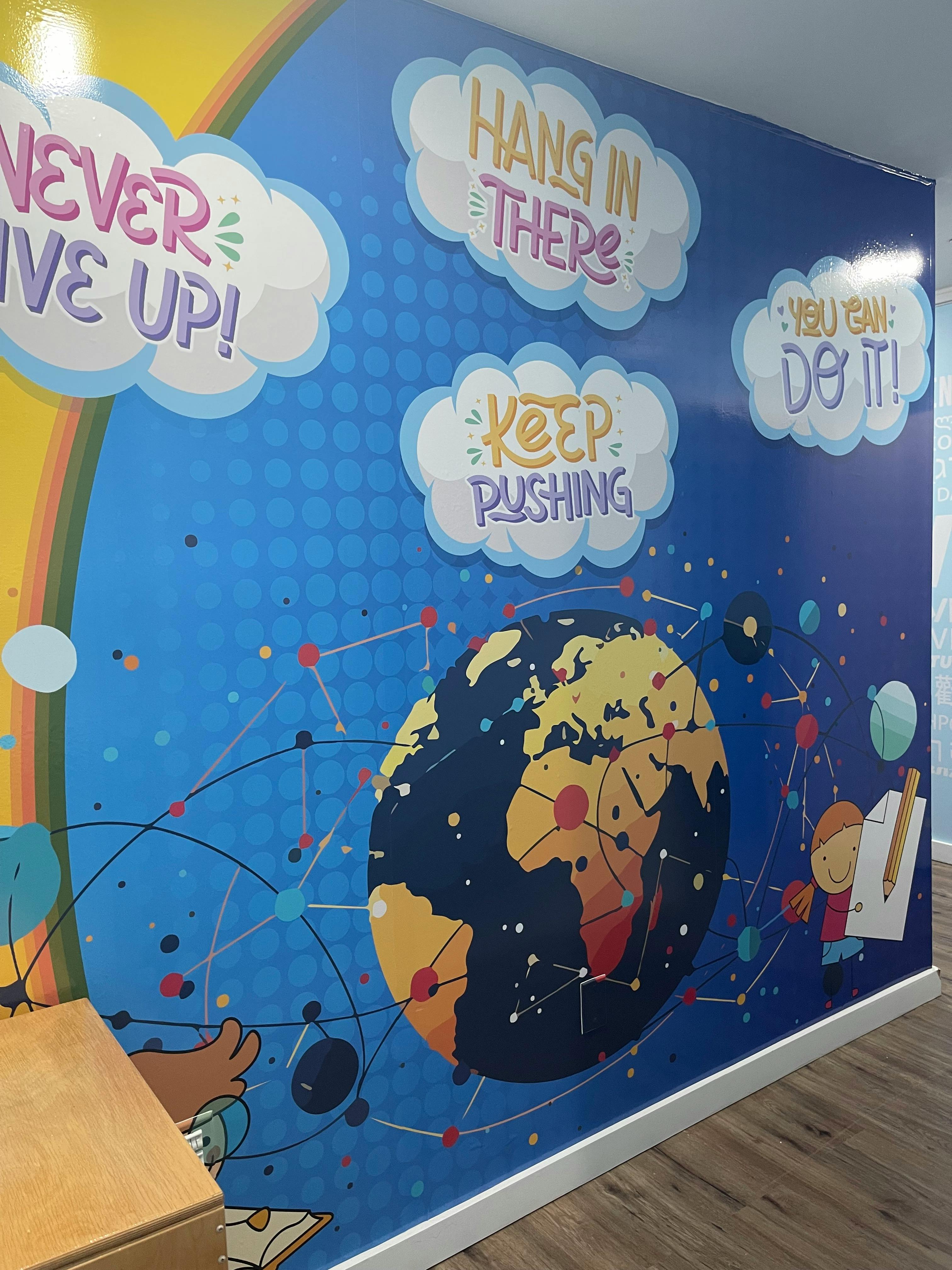 Wall mural with a globe, network lines, and motivational phrases in clouds