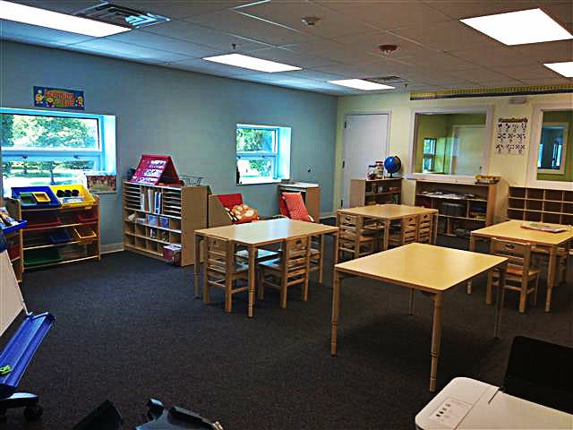 Empty classroom with small tables and chairs