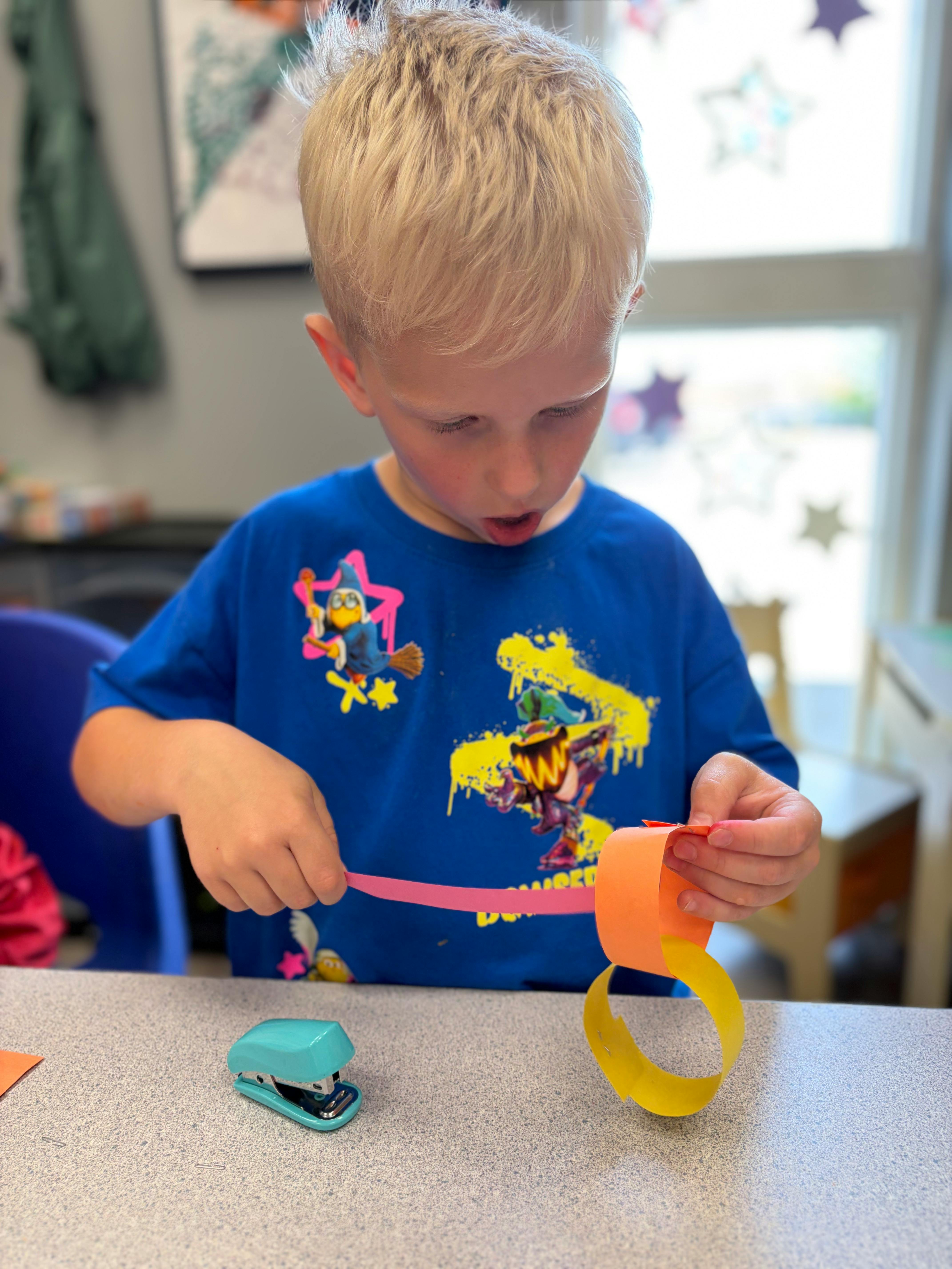 Child making a paper chain at a desk