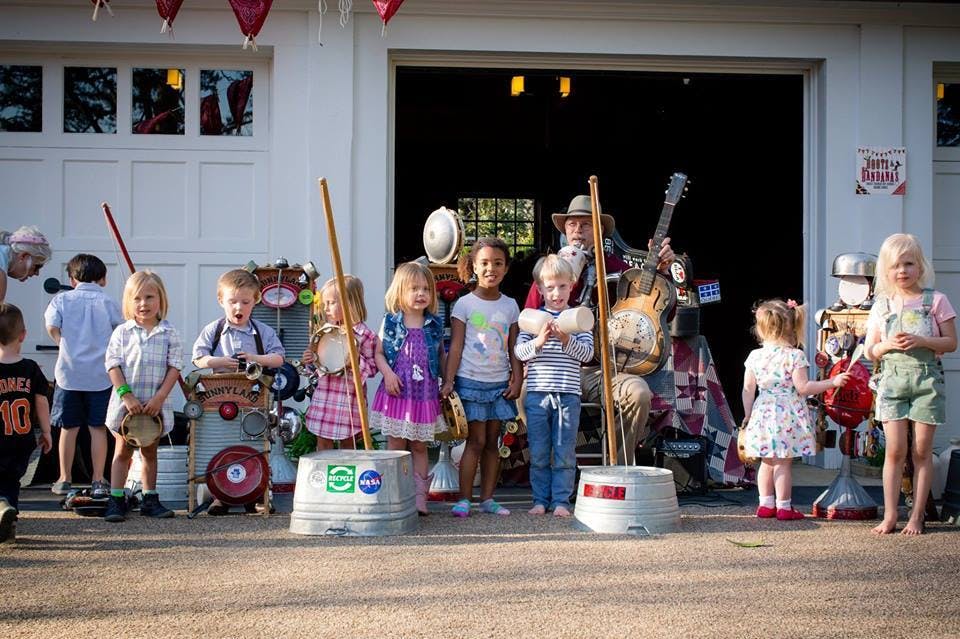 Children and adults playing musical instruments outdoors