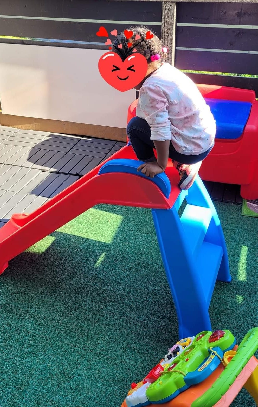Child climbing onto a plastic slide