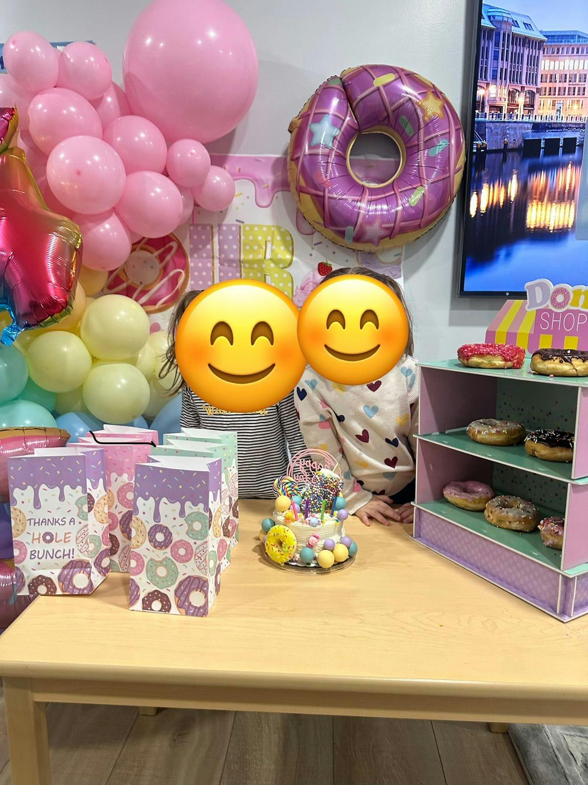 Two children at a donut-themed birthday party with cake and party favors