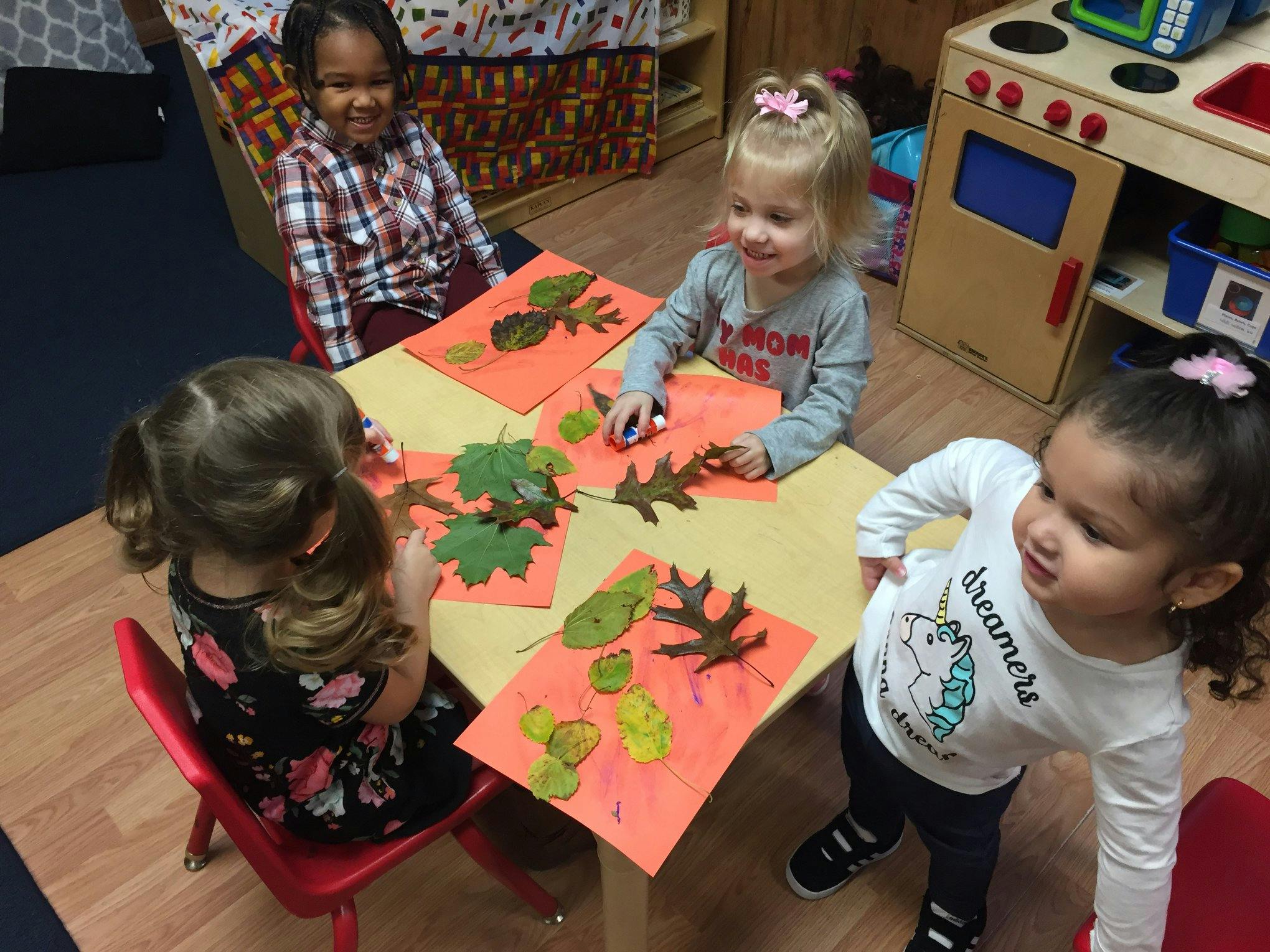 Children making leaf collages at a table