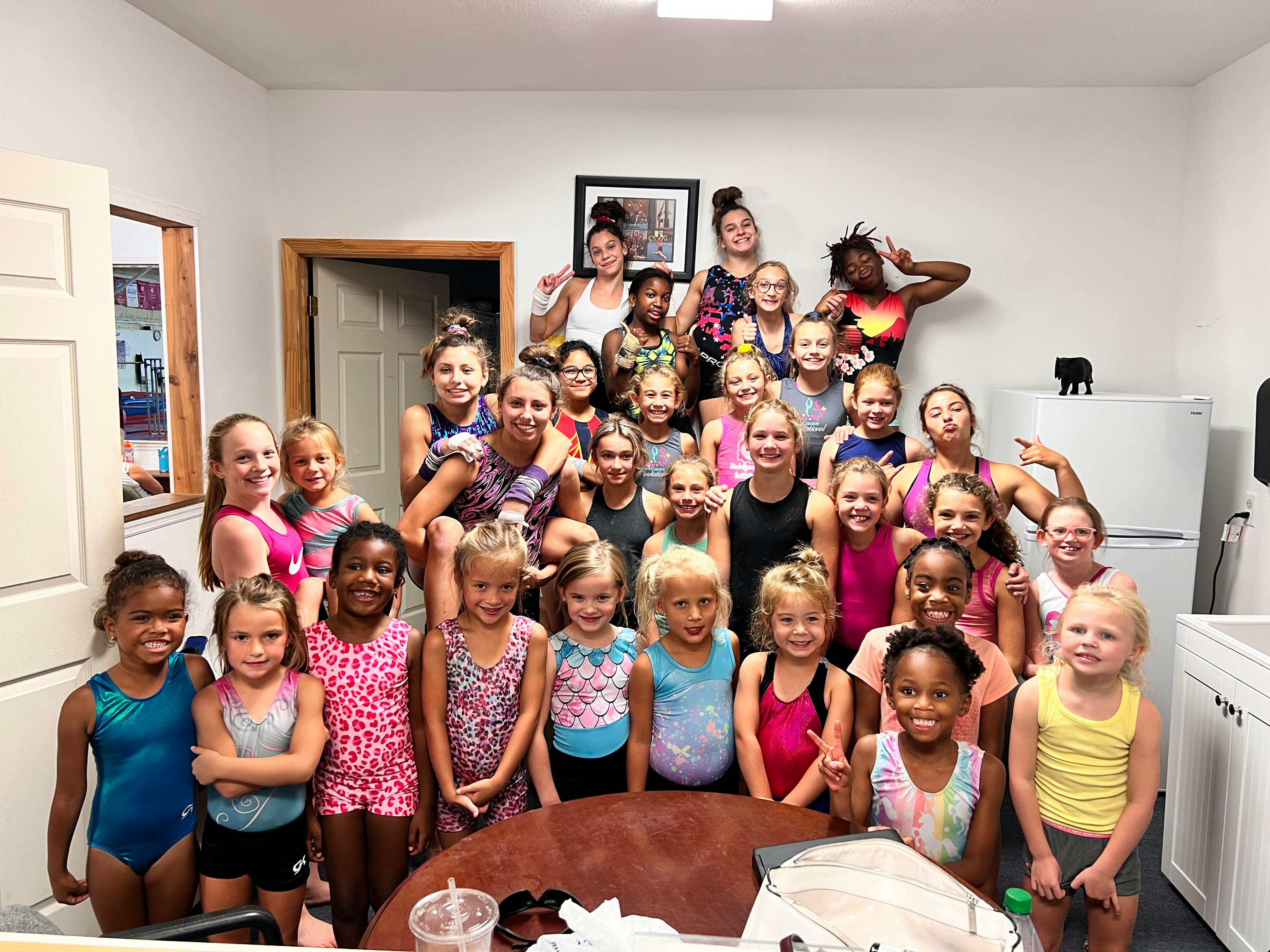 Large group of children and adults posing together indoors