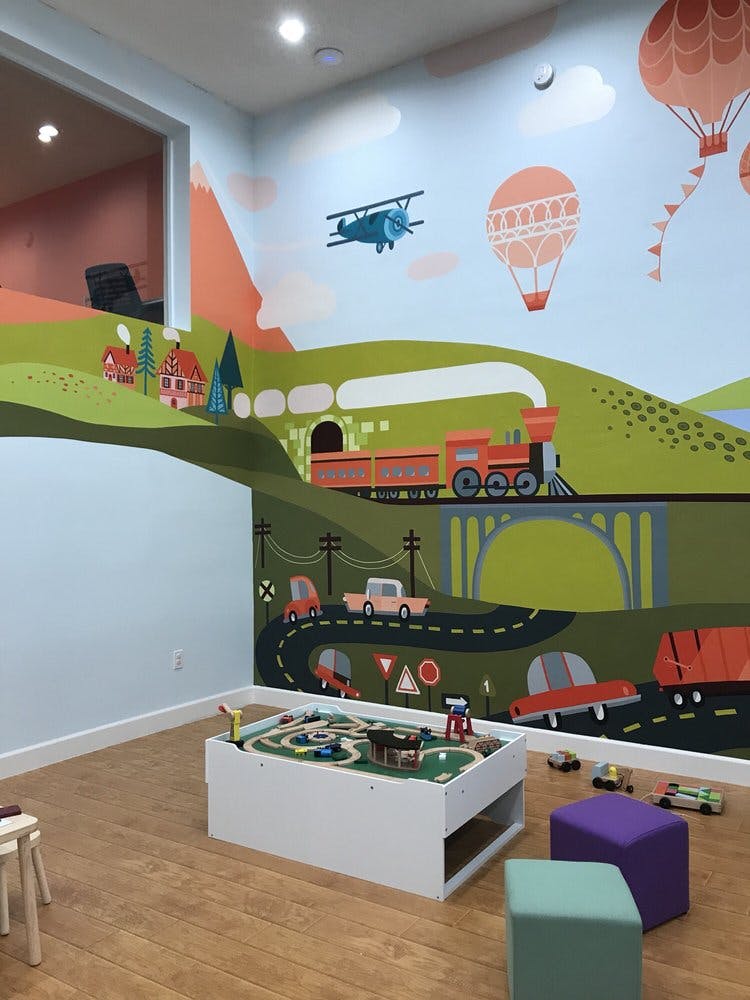 Playroom with a mural of a train, cars, airplane, and hot air balloons