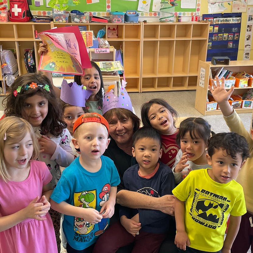 Adult and several children posing in a classroom