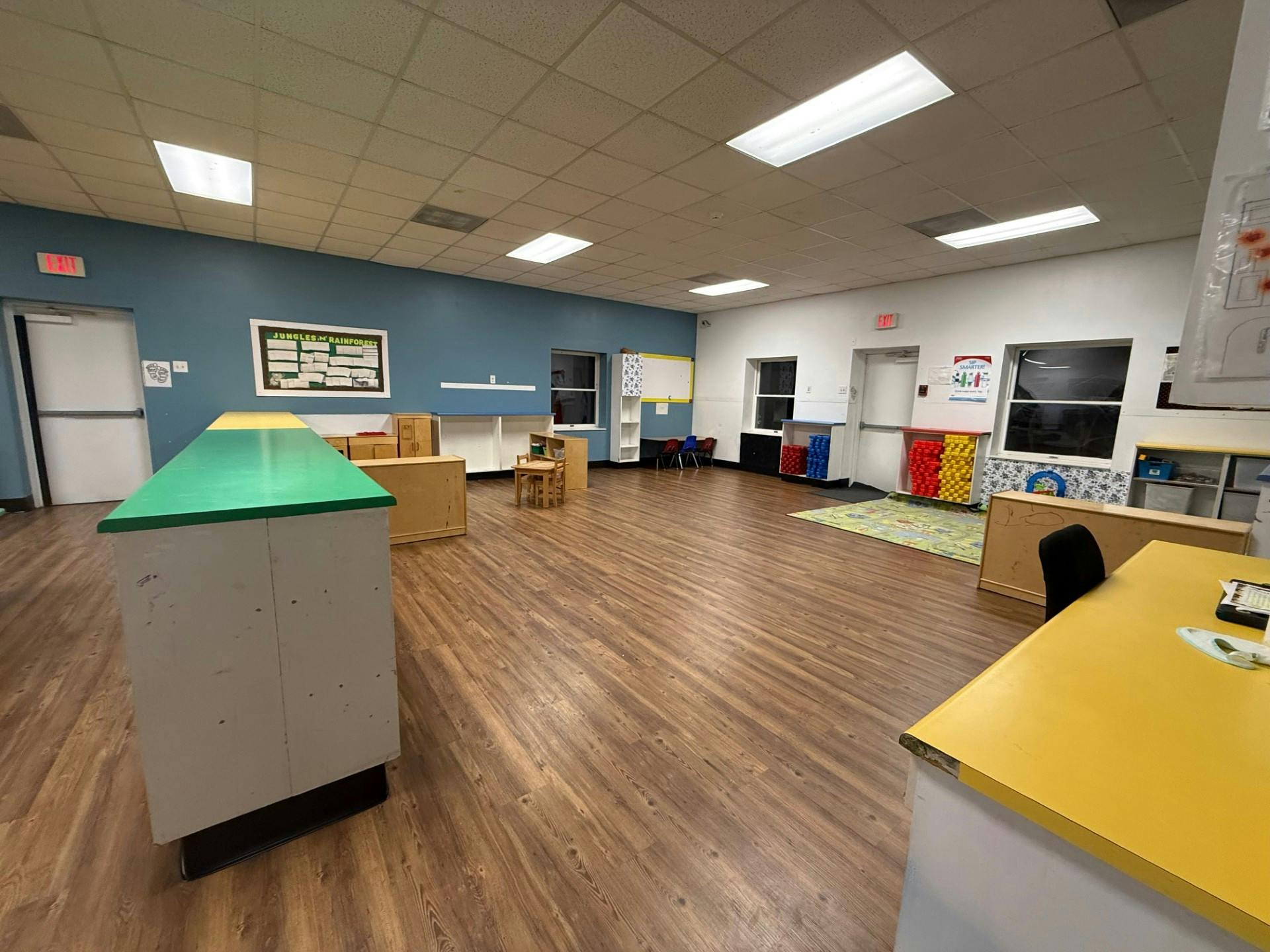 empty classroom with tables, chairs, and colorful shelving
