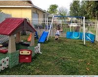 Child on a swing set in a backyard