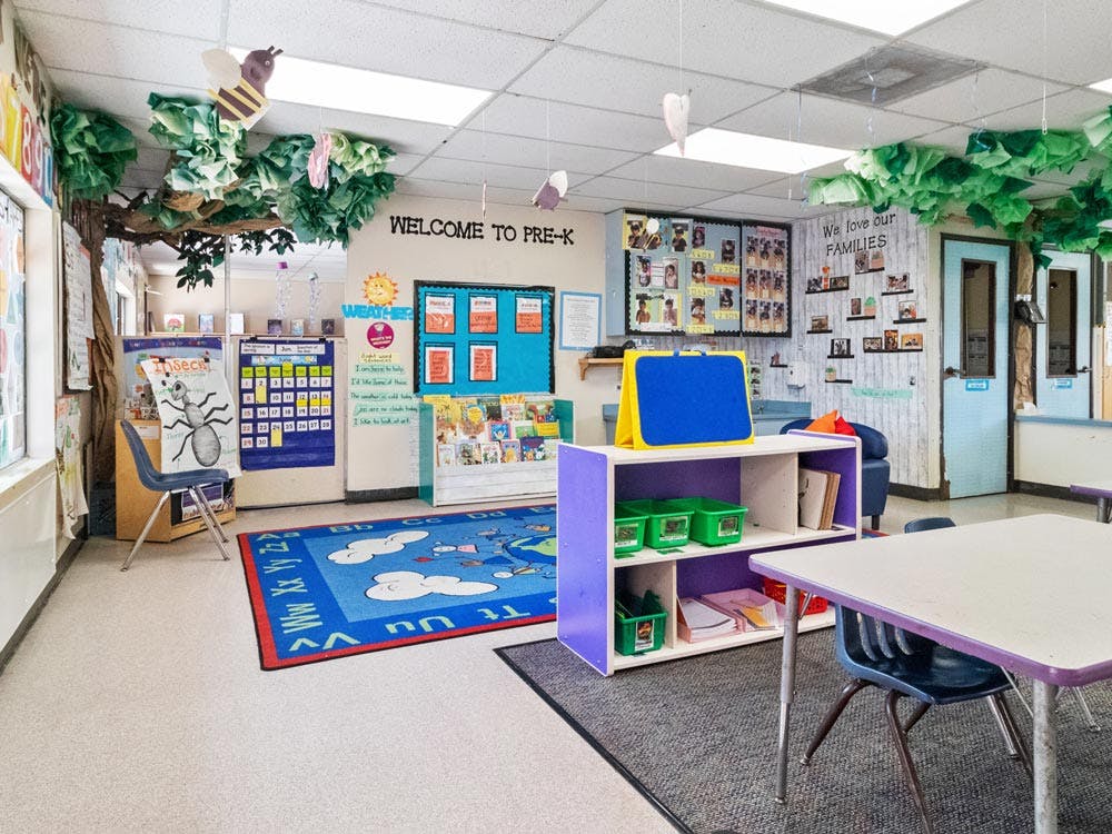 Classroom decorated for preschool children with tables, chairs, and colorful displays