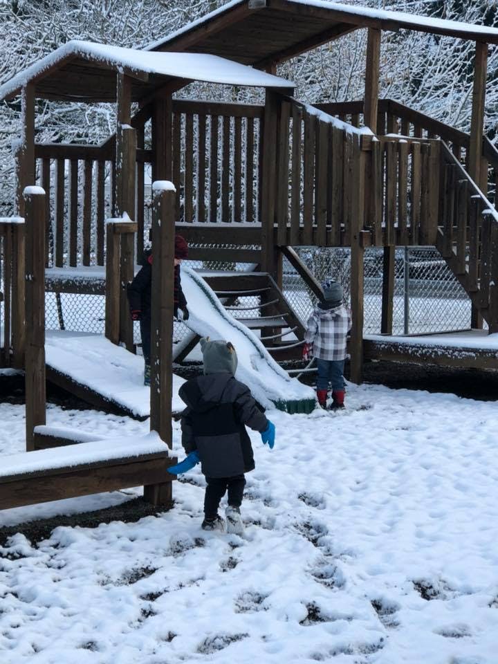 Children playing in snow on a playground