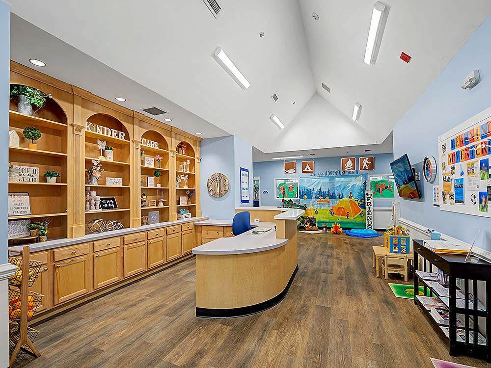Reception area with wooden bookshelves, counter, and play area