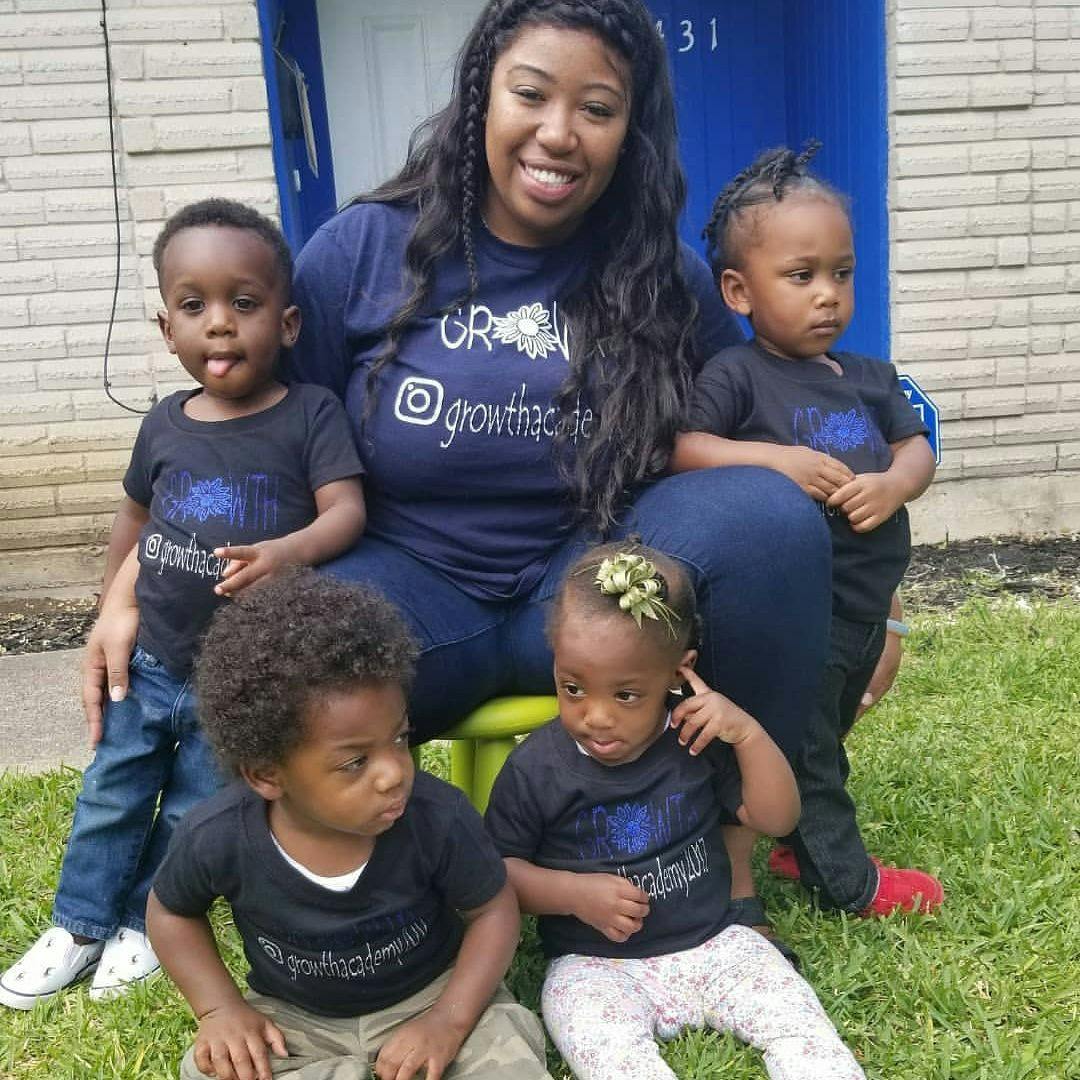 Person sitting with four children on grass