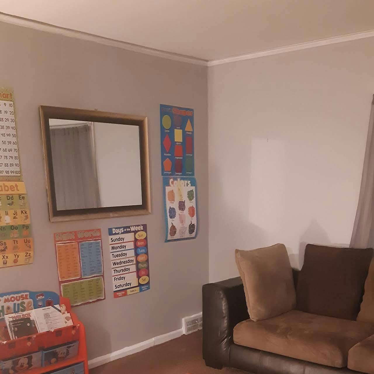 Wall with mirror, educational posters, and a couch