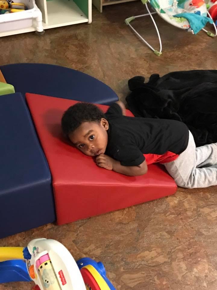 Child lying on red and blue soft play mats