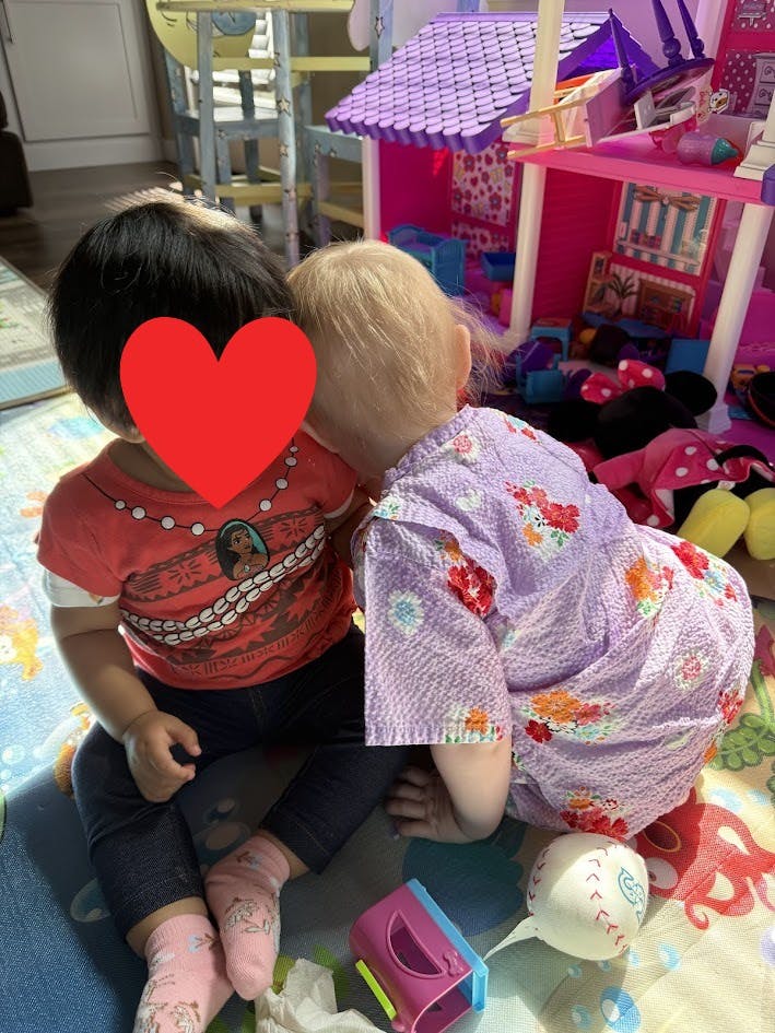 Two children playing with a dollhouse