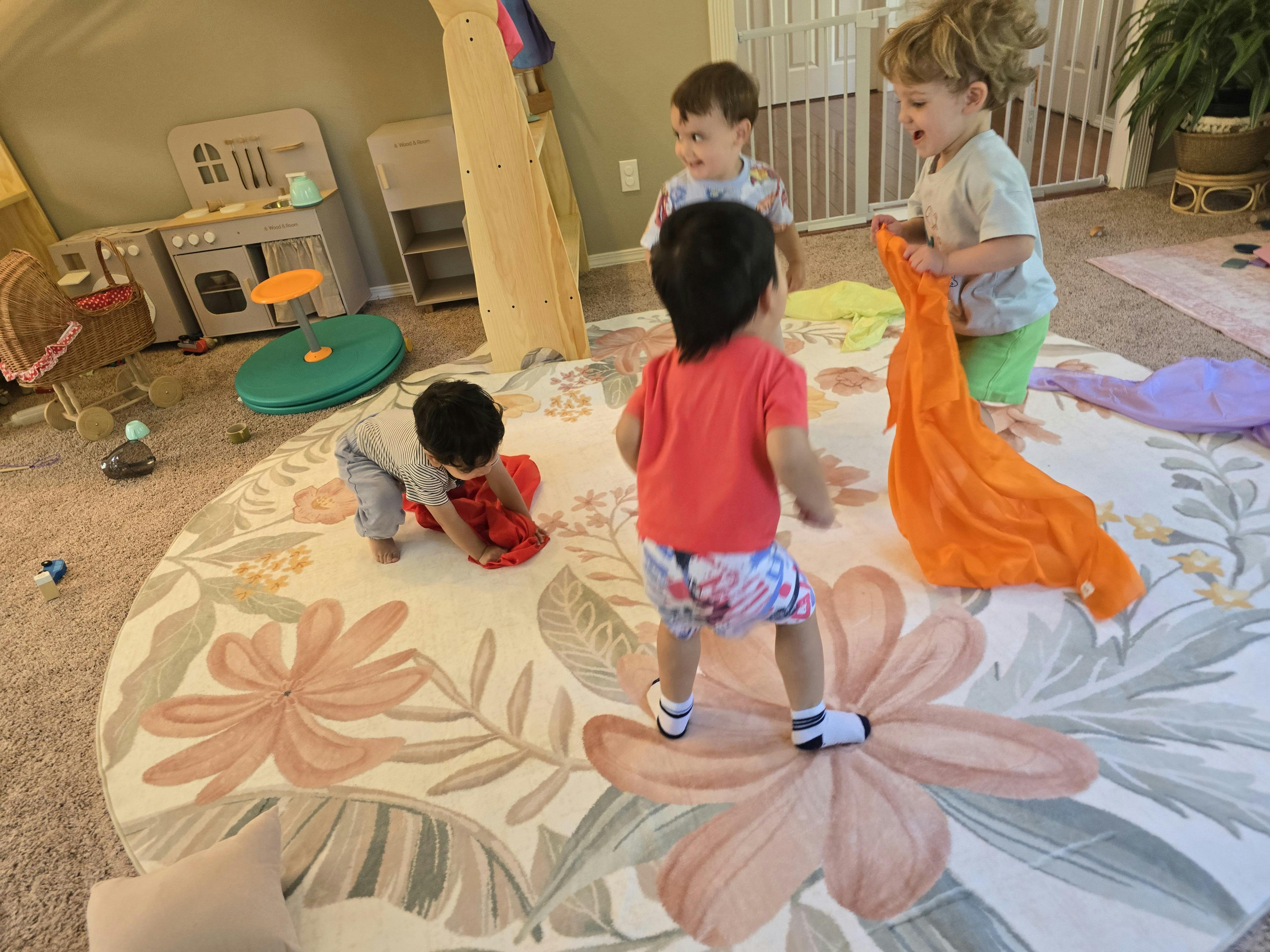 Four children playing on a floral rug