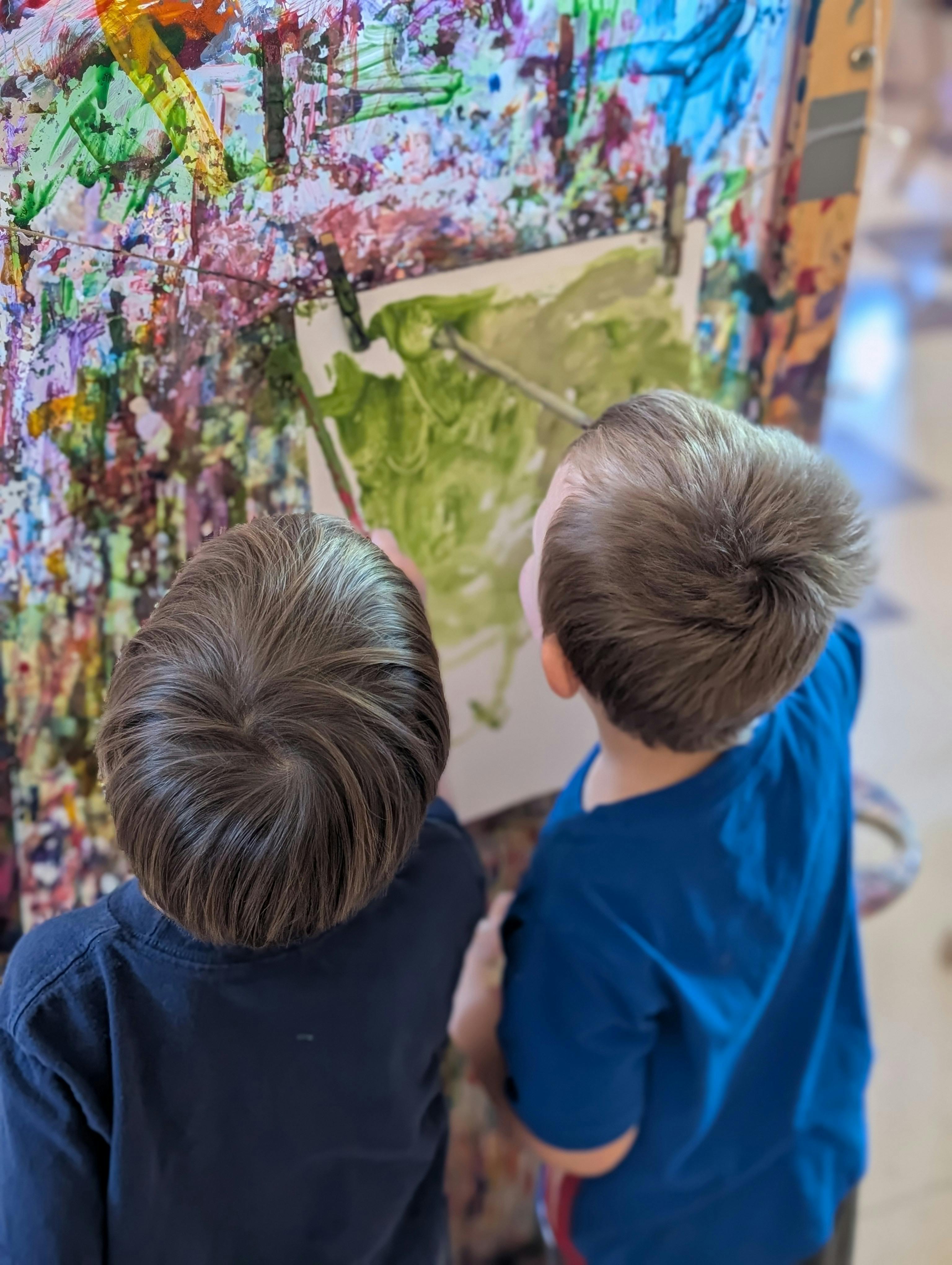 Two children painting on a canvas