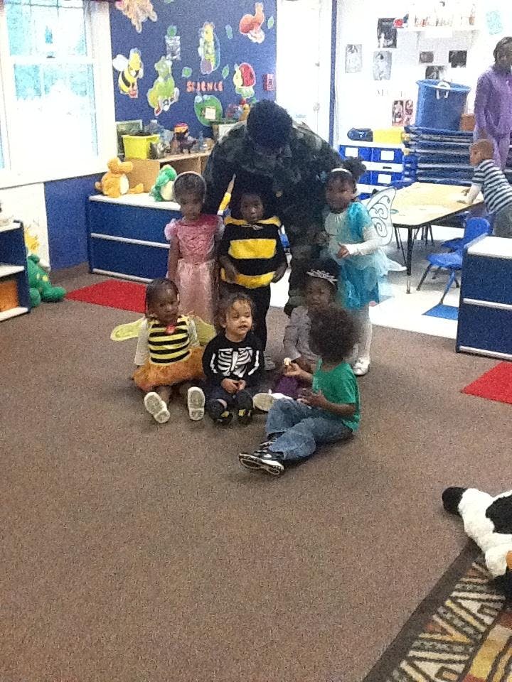 Adult and children in costumes in a classroom